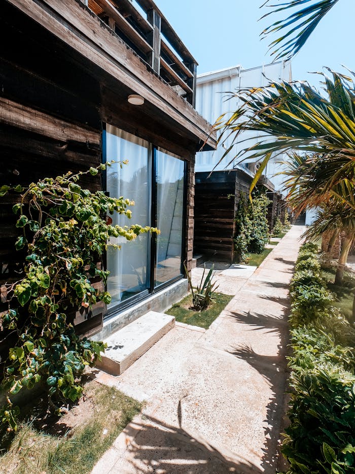Bright pathway beside beachfront villas in Adicora, Venezuela, framed by lush greenery.
